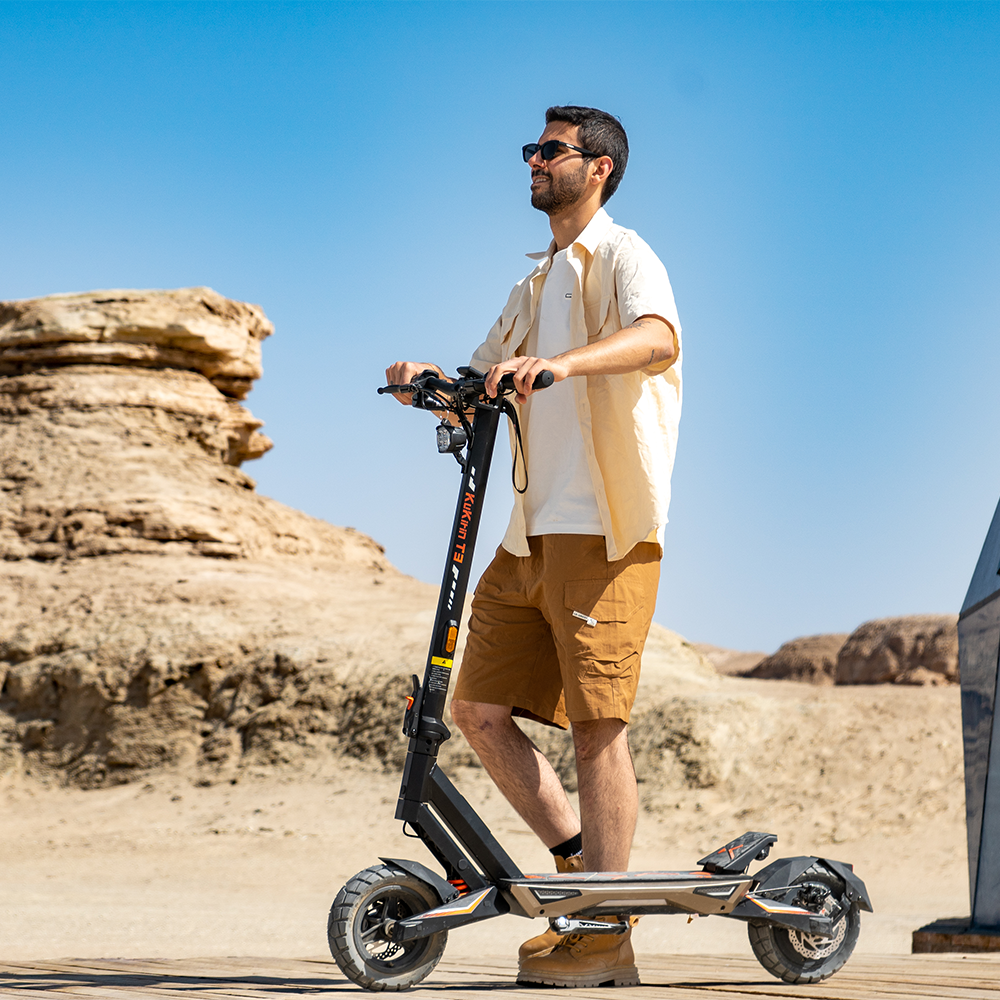 Rider using the KuKirin T3 electric scooter on a desert road