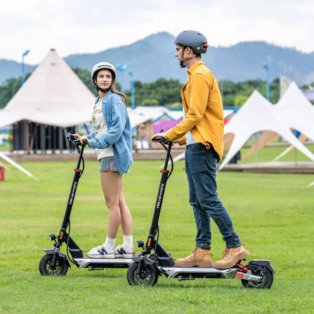 Two riders with KuKirin M4 Max electric scooters outdoors